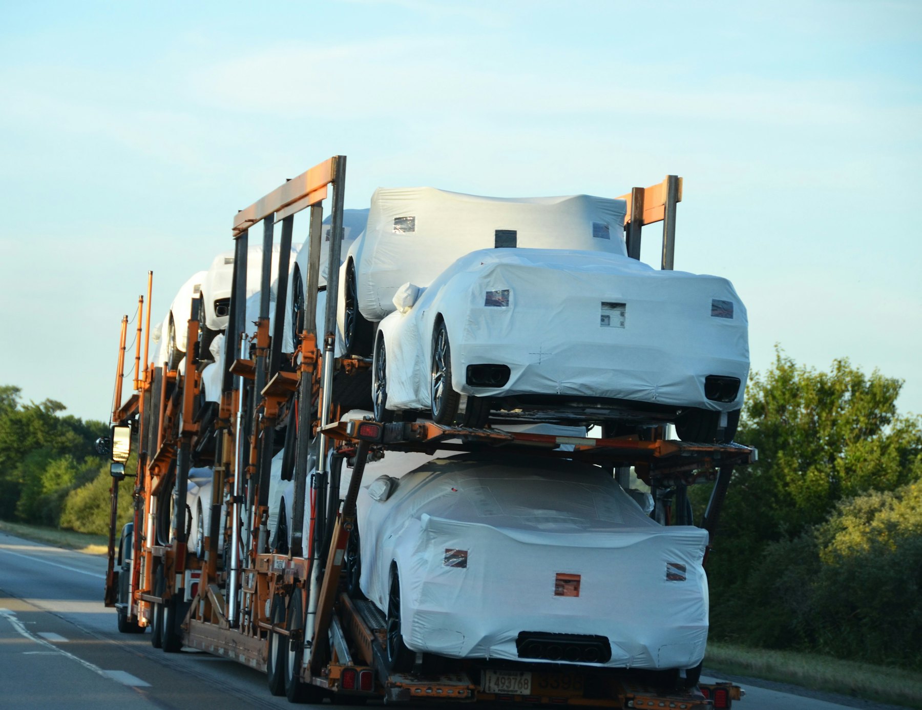 Car carrier loaded with covered new vehicles